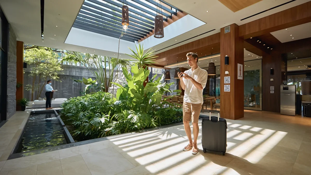 Hotel guest scanning QR code with smartphone in resort lobby, demonstrating easy feedback collection